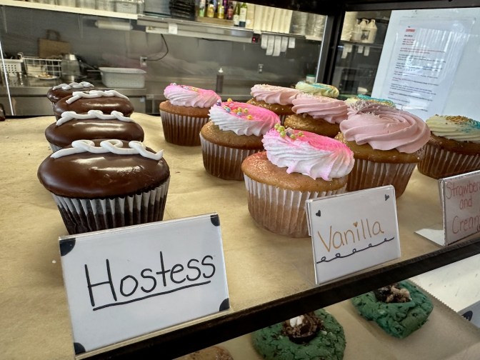 Cupcakes sitting behind counter.