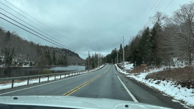 View of NY-28 with snow on both sides of road.