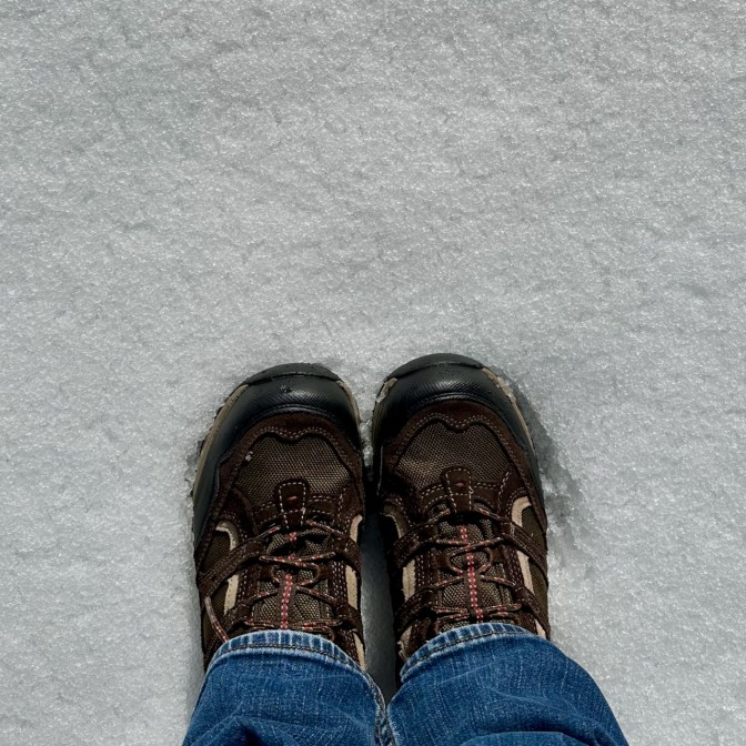 Two boots standing in snow.