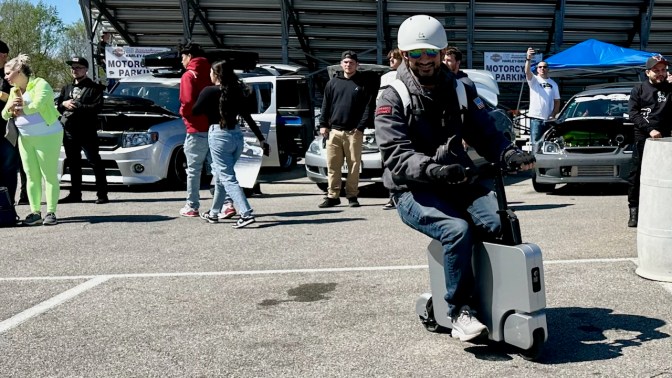 Man riding silver Motocompacto.
