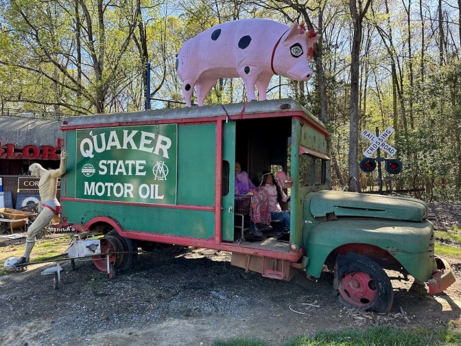 Motor oil truck with a pig statue on top.