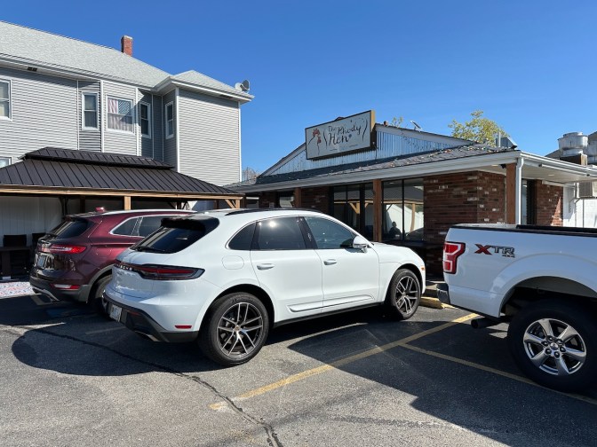 Exterior of The Rhody Hen Cafe, with cars parked in front of it.