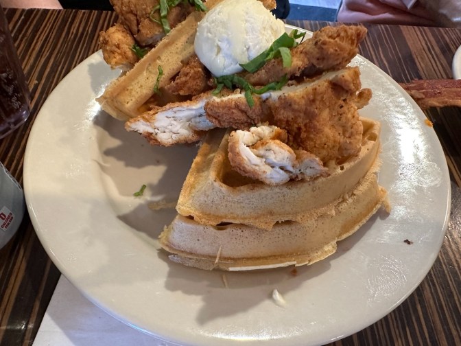 Chicken and waffles on plate.