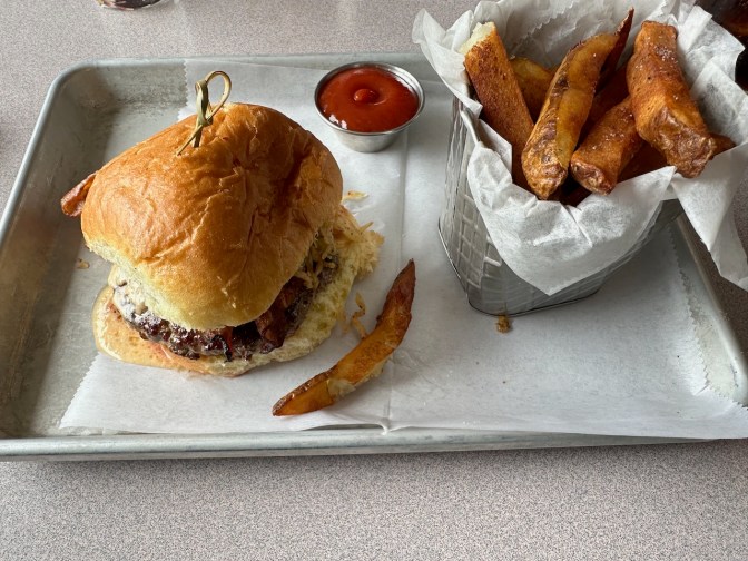 Burger and fries on silver platter.