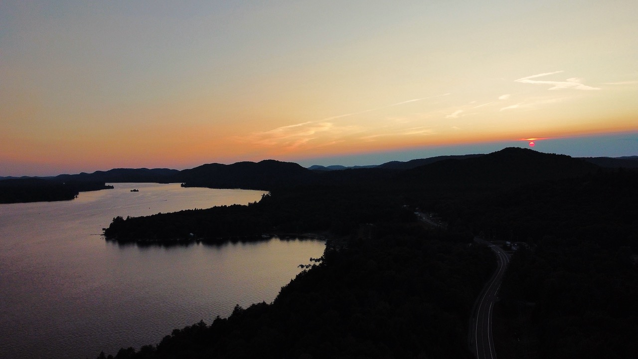 Aerial sunset view of lake and mountains.