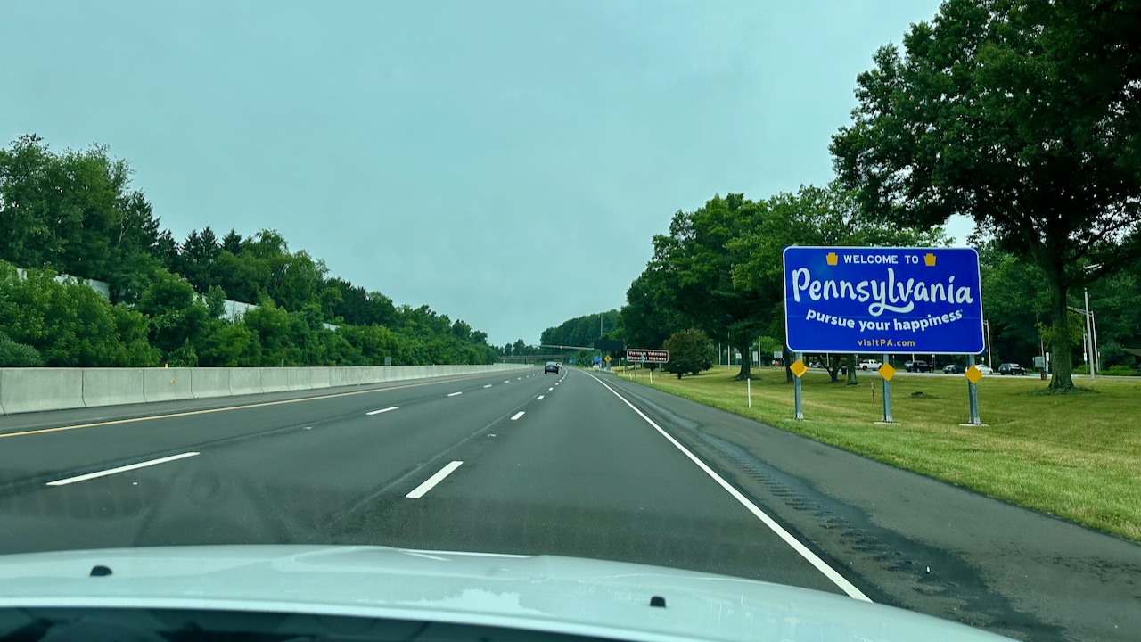 View of I-295 in Pennsylvania with WELCOME TO PENNSYLVANIA sign on right side of road.