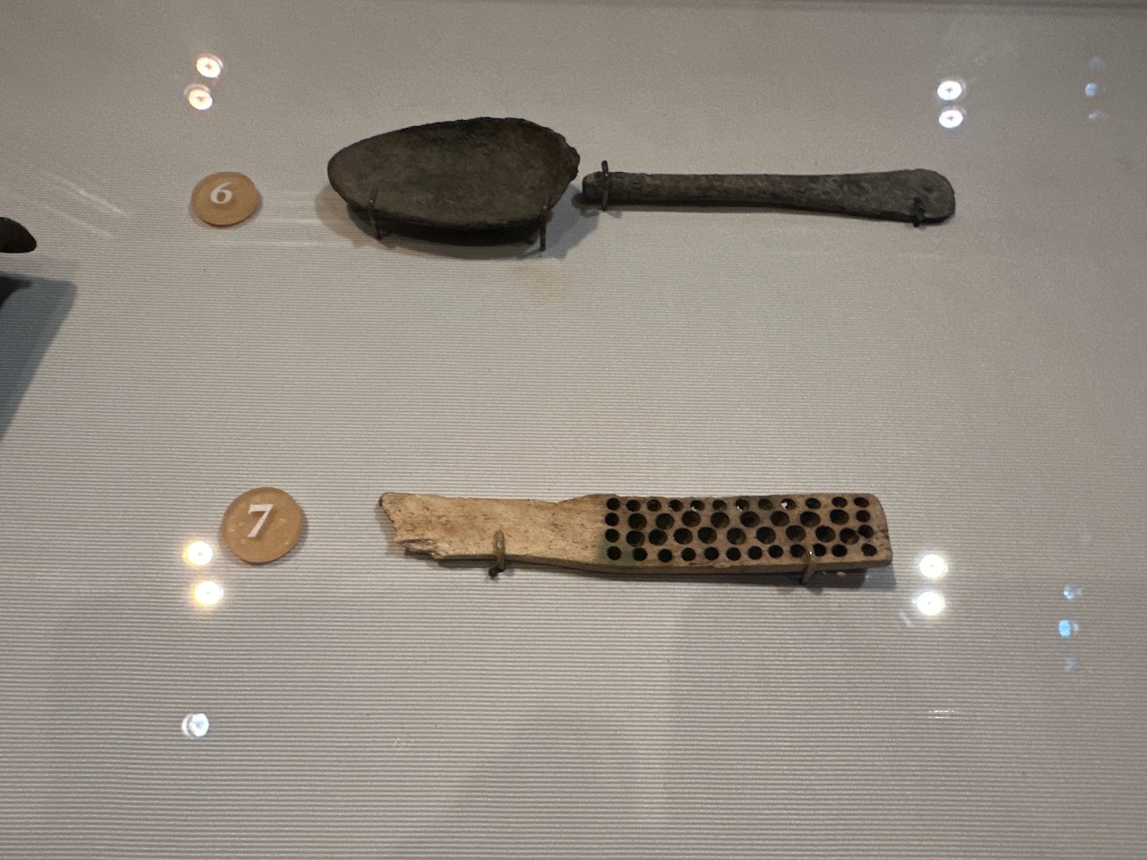 Spoon and hairbrush in display case.