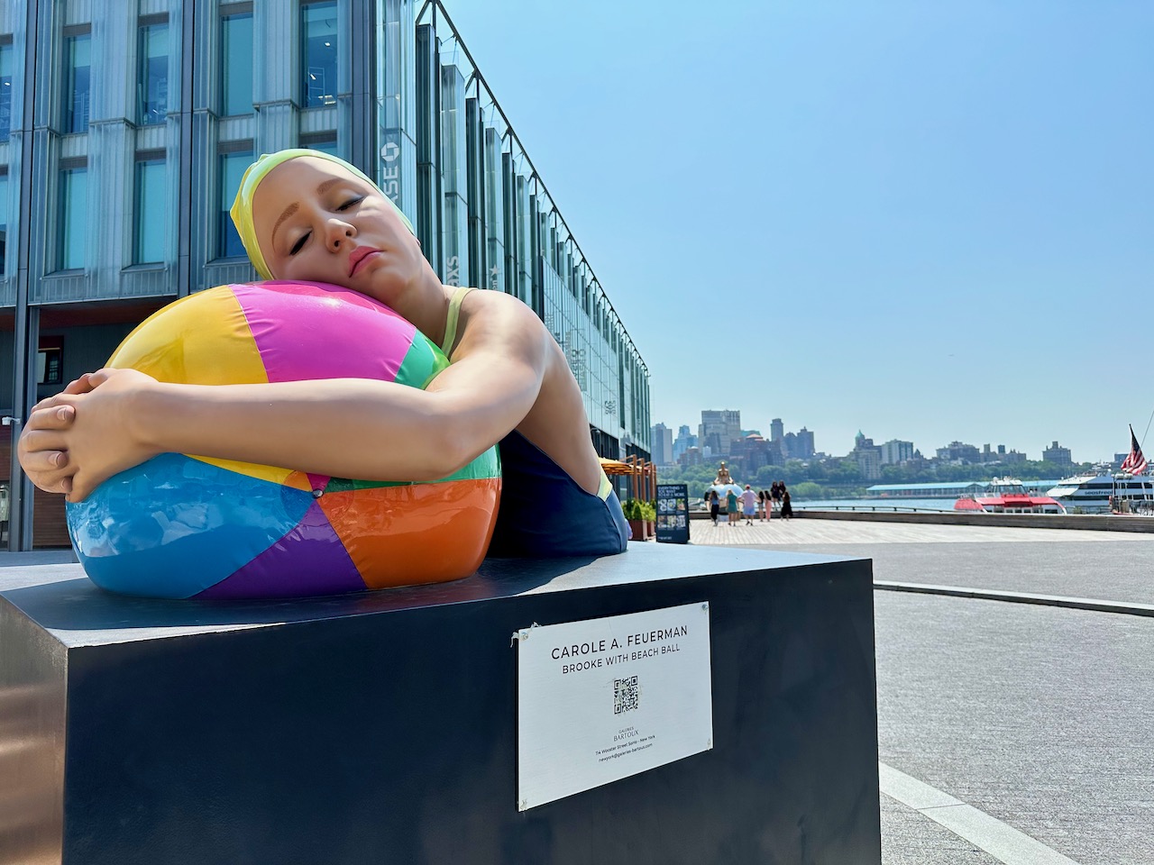 Statue of woman holding beach ball.