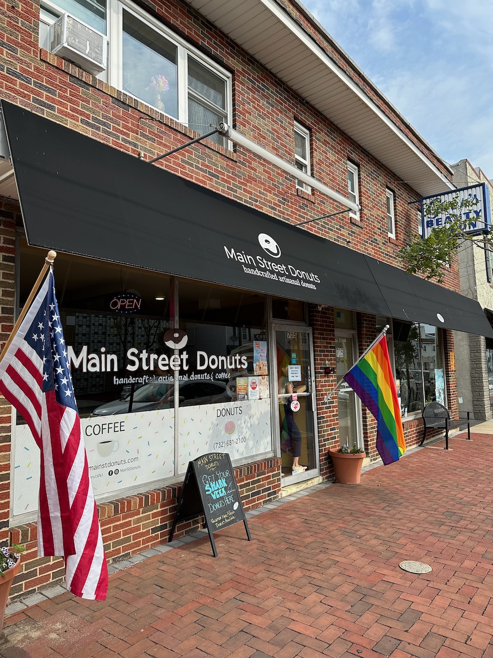 Exterior of Main Street Donuts, a shop in a two-story brick building.