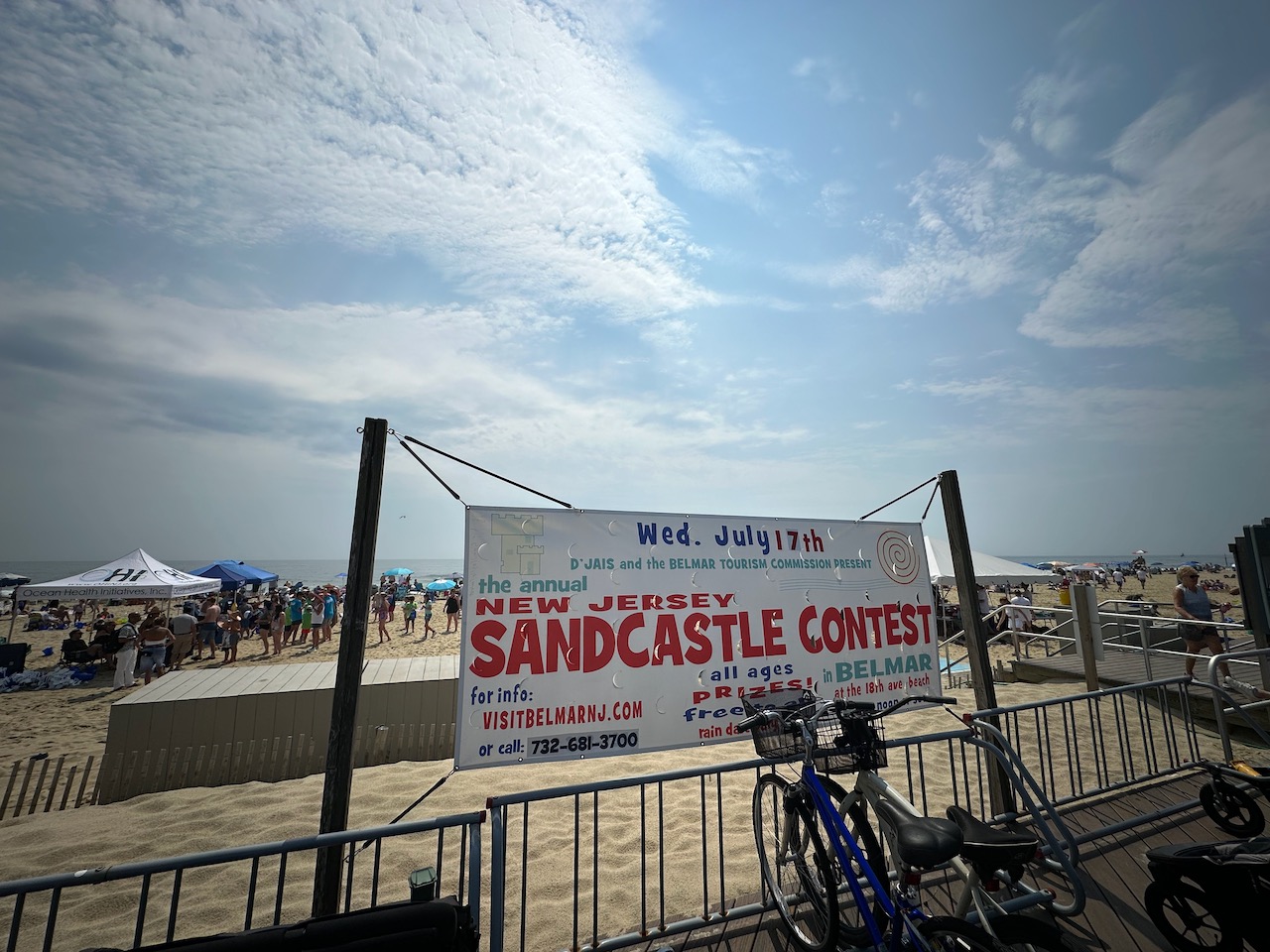 Sign beside beach that says THE ANNUAL NEW JERSEY SAND CASTLE CONTEST.