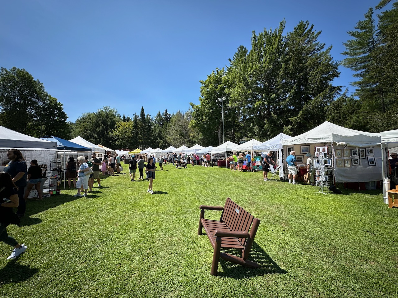 Field with pop up tents for merchants at arts and crafts fair.