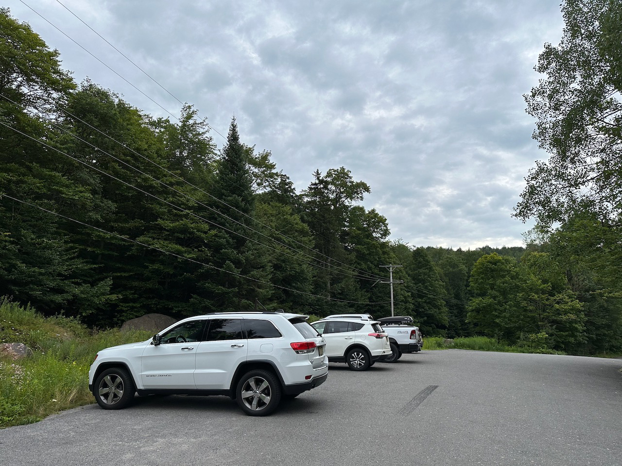 2014 Jeep Grand Cherokee in gravel parking lot. Two other vehicles are in the lot as well.