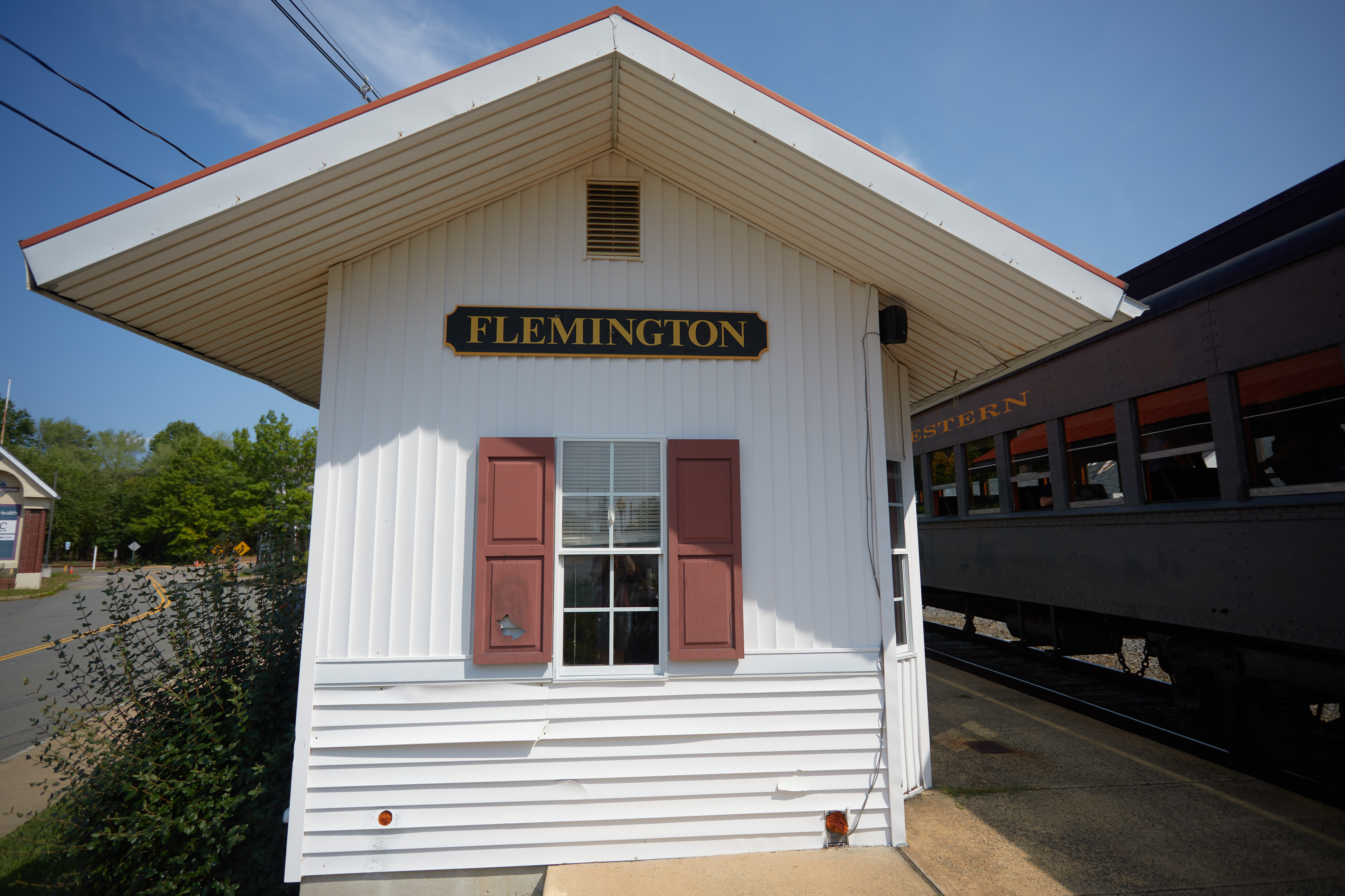 Flemington Station house, with passenger train on track beside it.