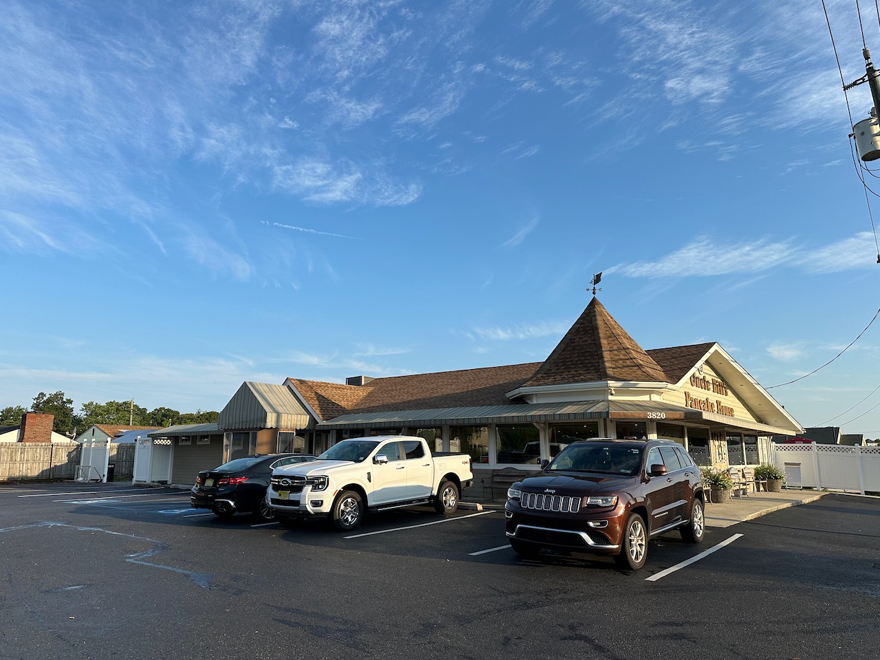 Exterior of Uncle Bill's Pancake House, with three vehicles parked in parking lot.