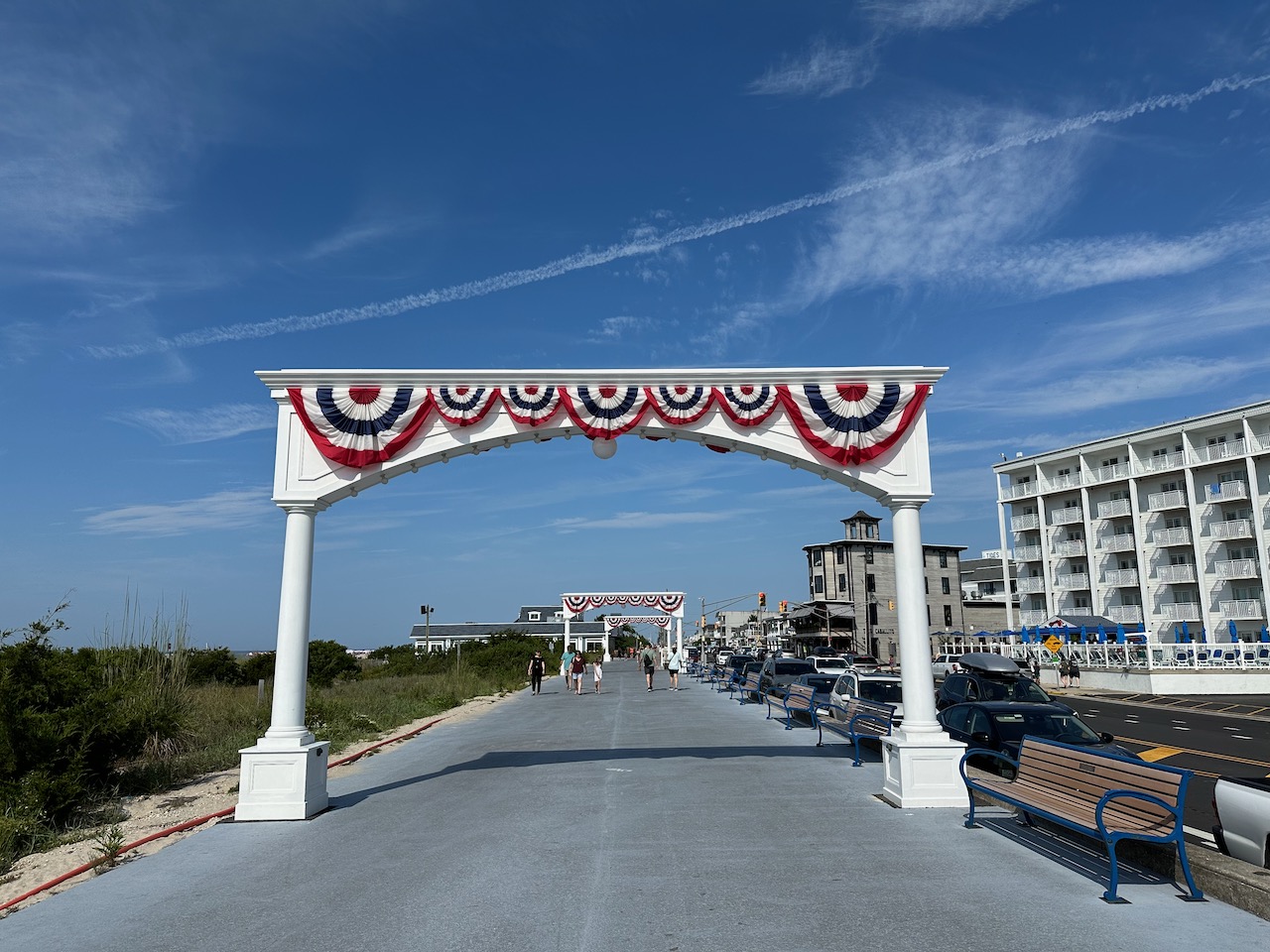 Promenade along Beach Drive in Cape May. A large arch is in the foreground, with red-white-and-blue bunting.