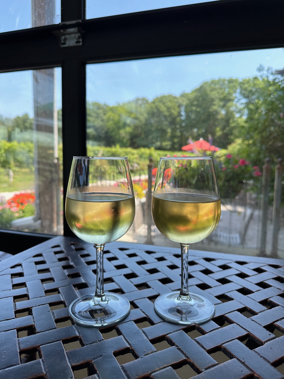 Two glasses of wine on metal table.