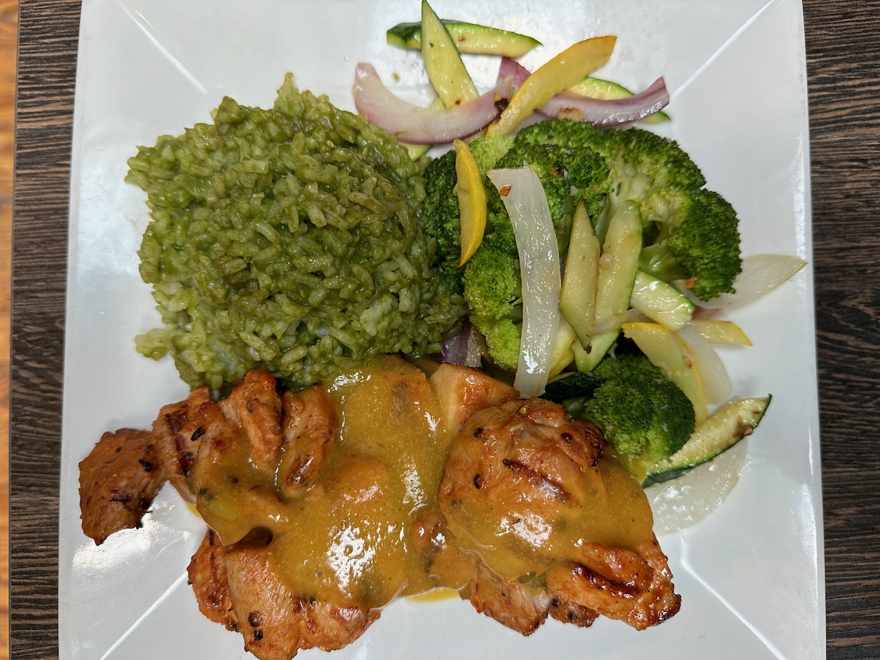 Maple bourbon chicken thighs, rice, and vegetables on white plate.