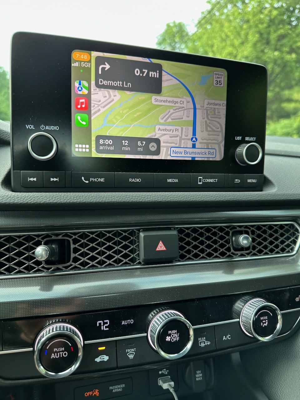 Center stack of dashboard including HVAC controls and infotainment unit.