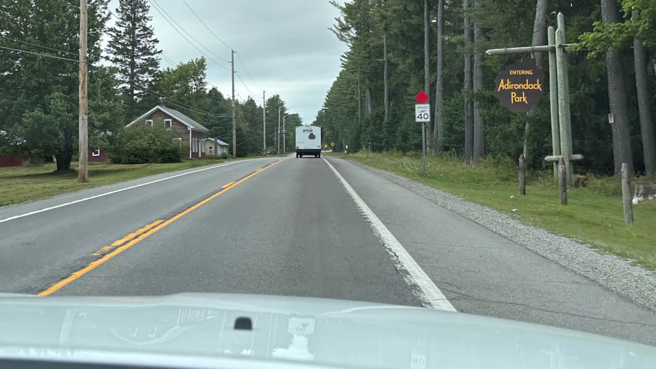 NY-28 with sign on side of road that says ENTERING ADIRONDACK PARK.