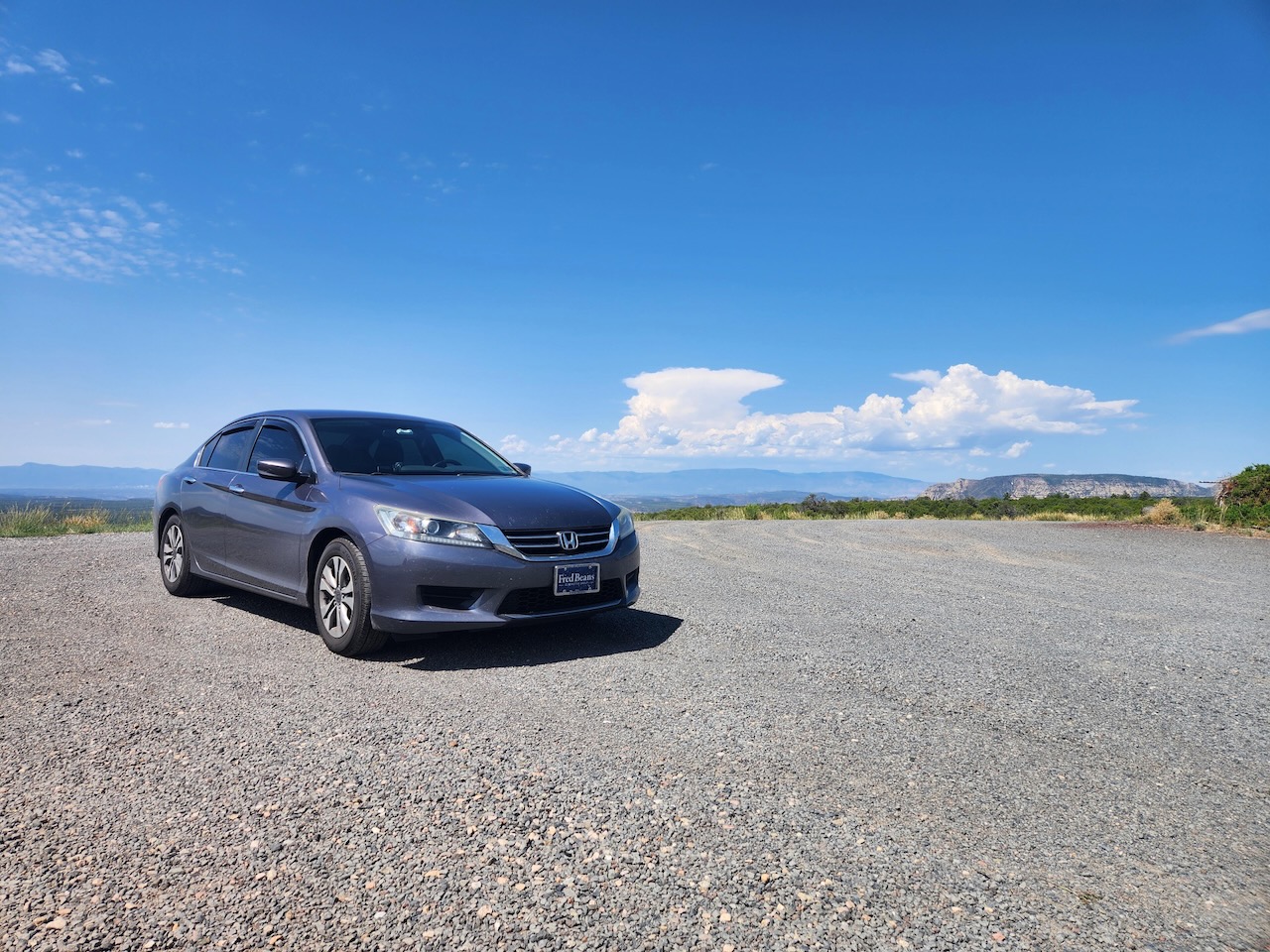 2014 Honda Accord sedan parked in gravel parking lot. It is a sunny day with blue skies.