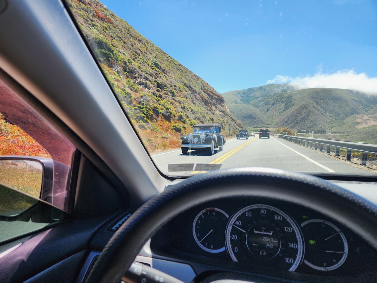 View of classic cars in opposite lane on Pacific Coast Highway.