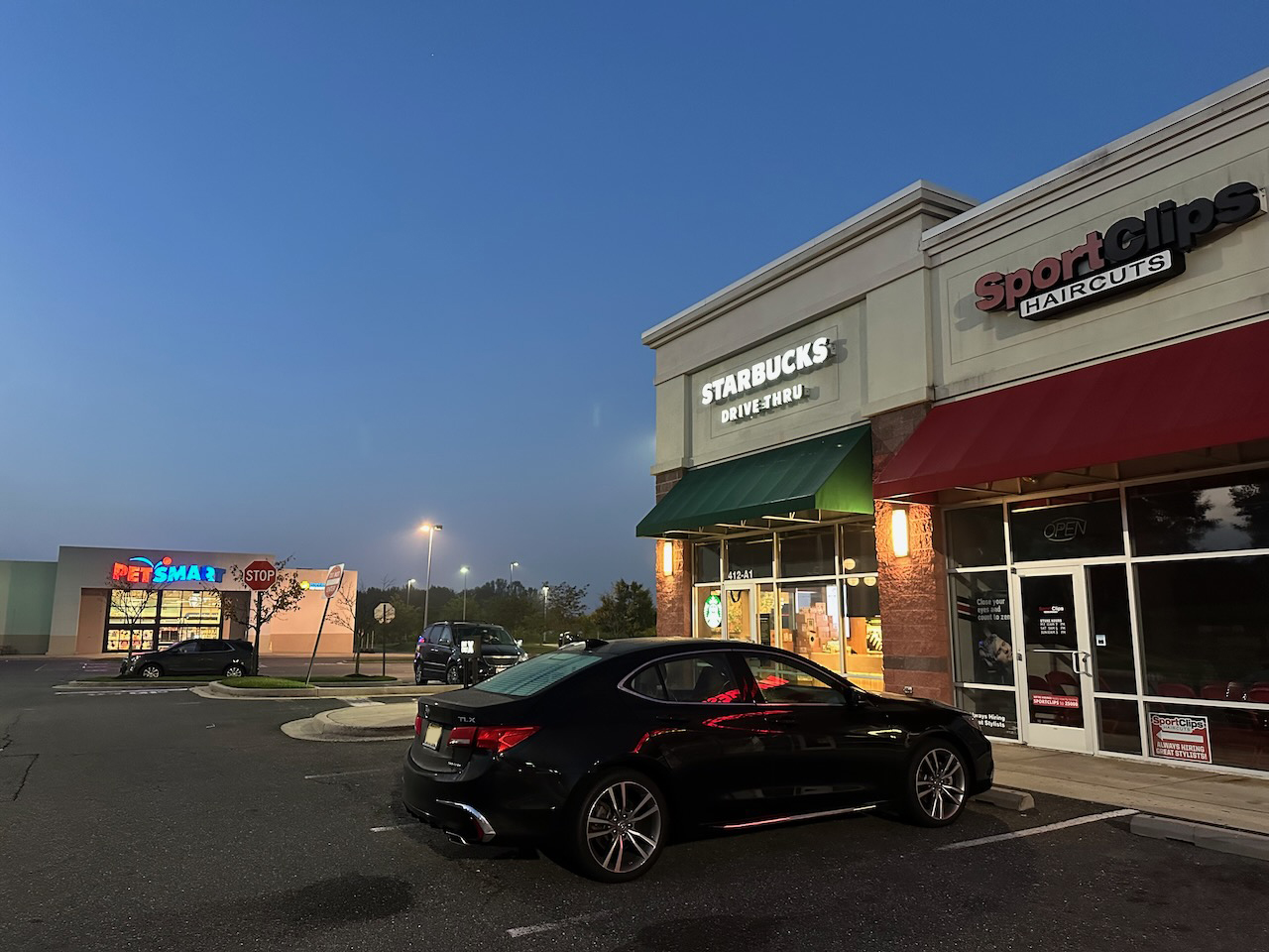 2020 Acura TLX parked outside of Starbucks and SportsClips in strip mall.
