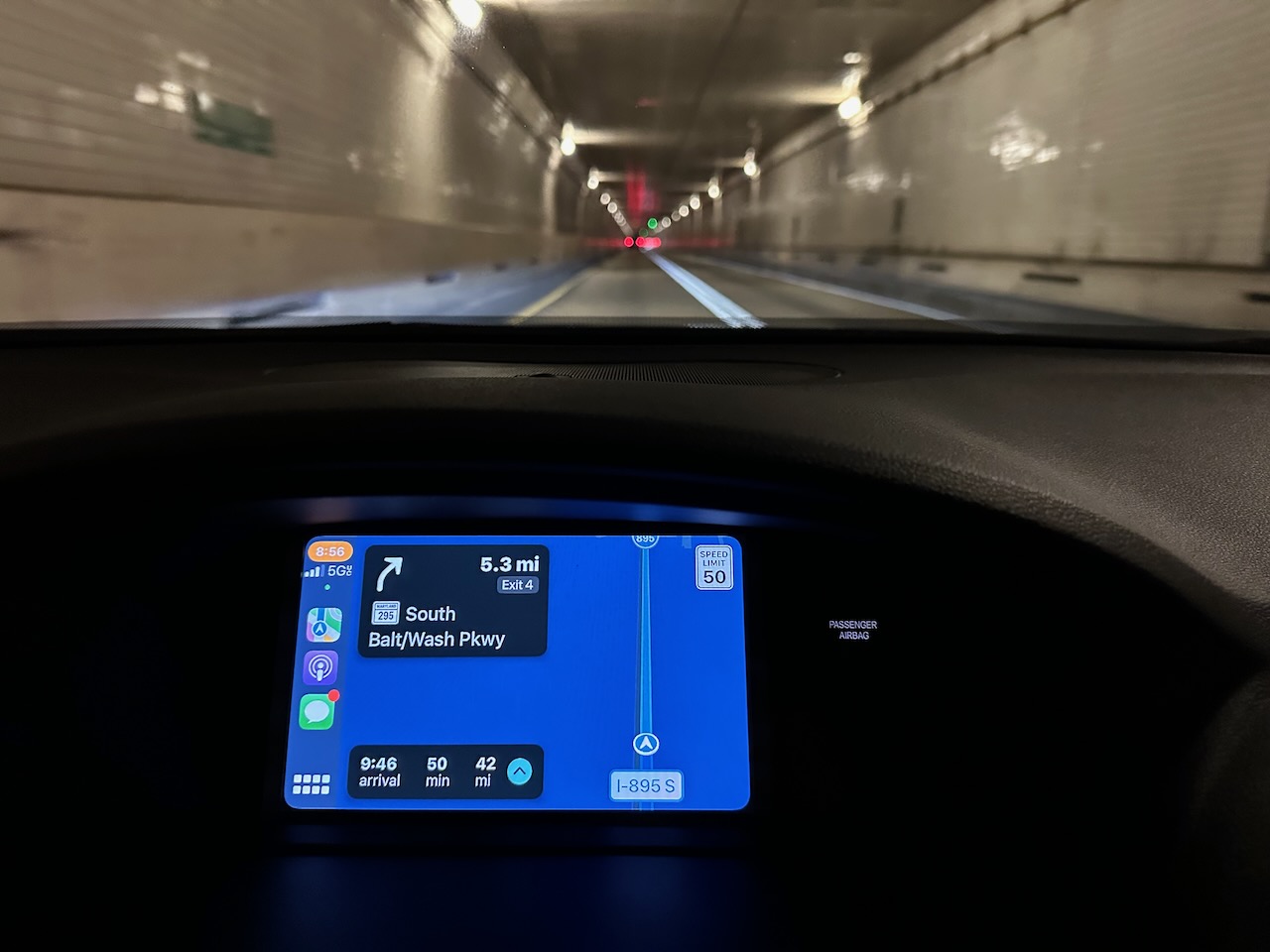 View of GPS map on car dashboard, with harbor tunnel in background.