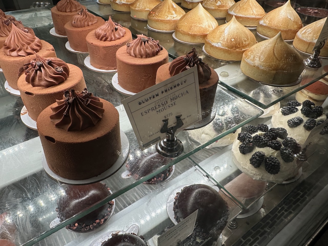 Cooler with cakes and mousses on display.