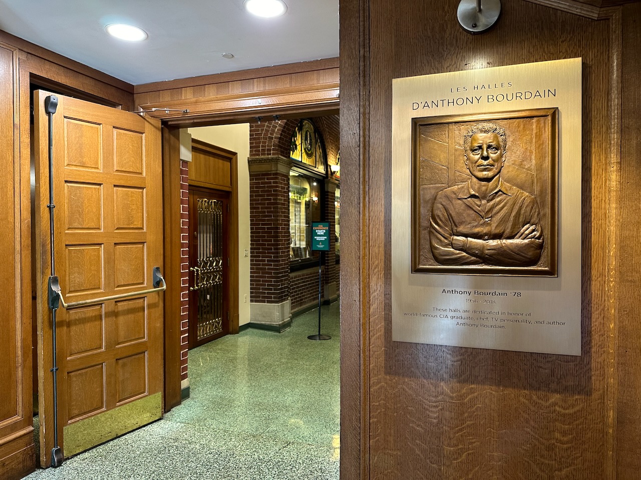 Anthony Bourdain Hallway, with descriptive plaque on wall on right.