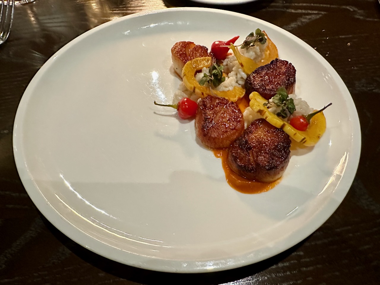 Scallops, coconut Carolina rice, and squash on plate.