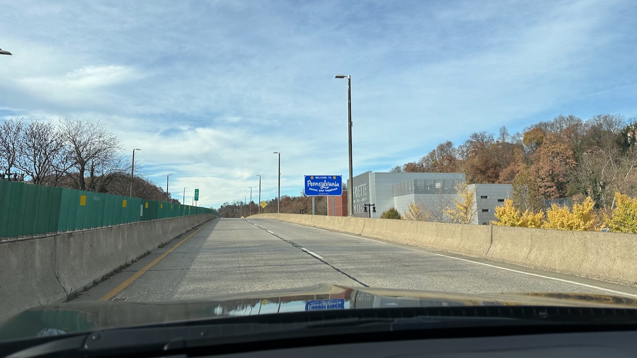 Welcome to Pennsylvania sign along side of two-lane road.