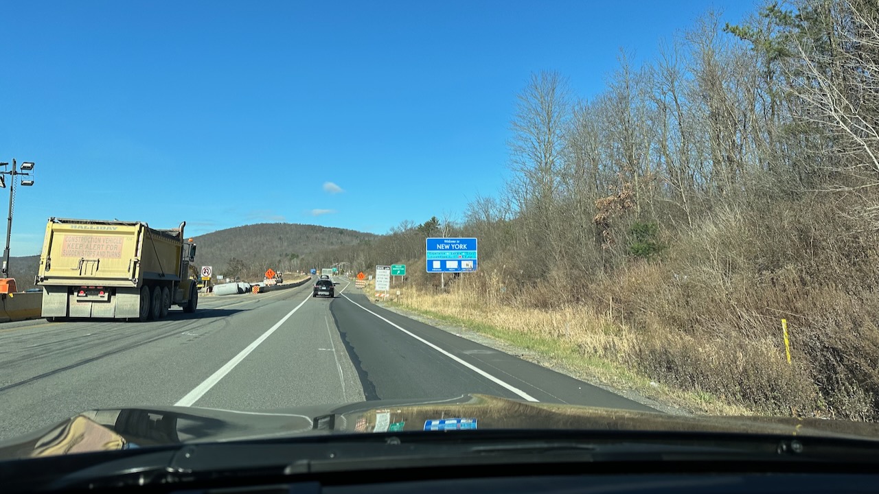 Welcome to New York sign along side of highway.