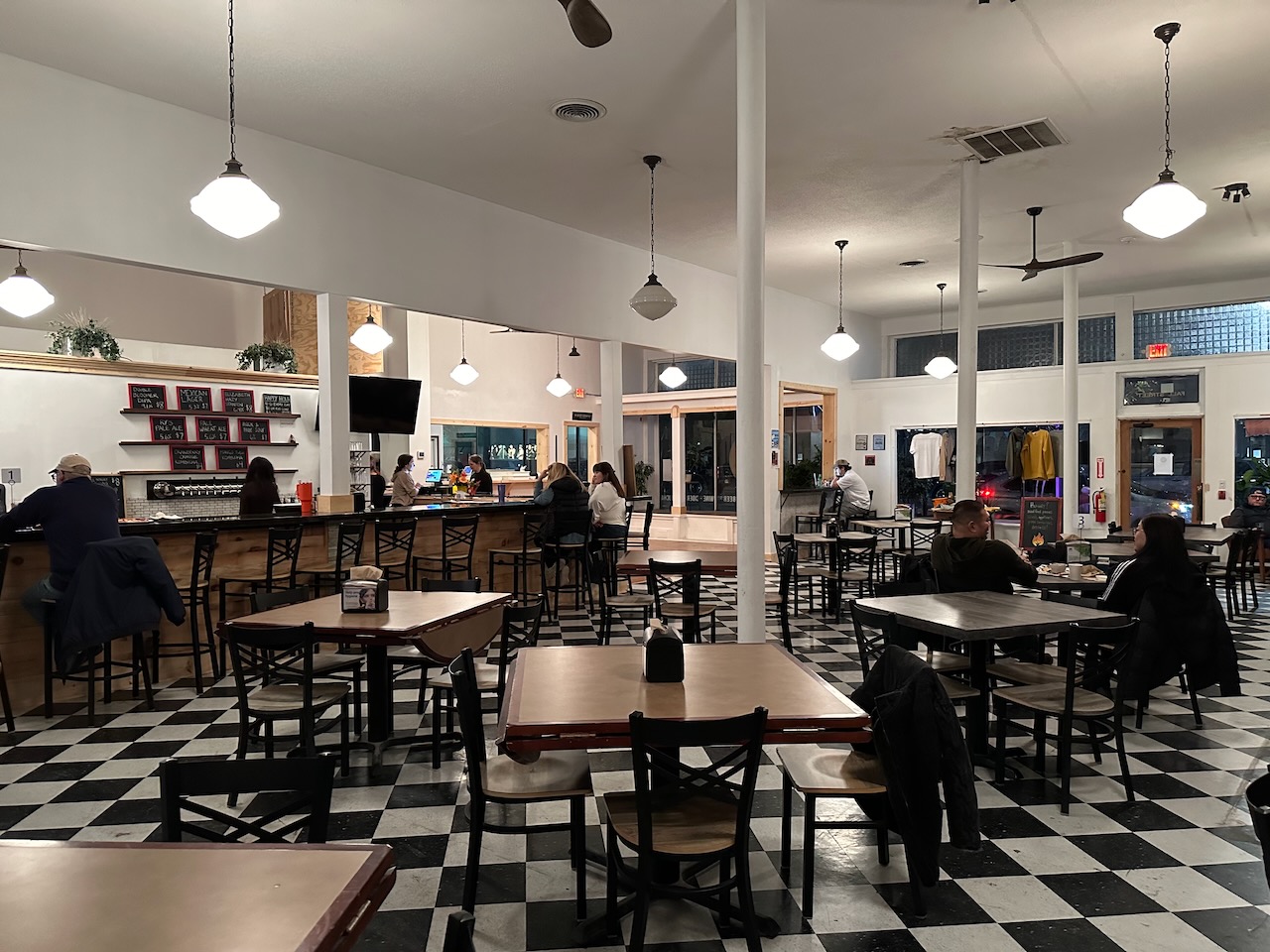 Interior of Fall Street Brewery with tables and bar visible.