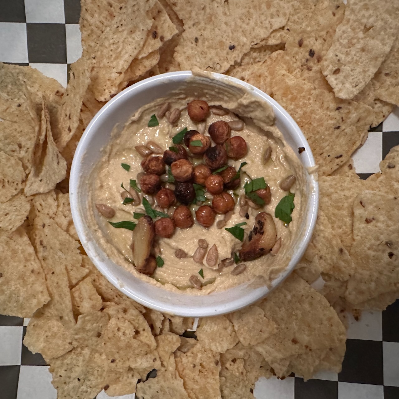 Hummus and tortilla chips on platter.