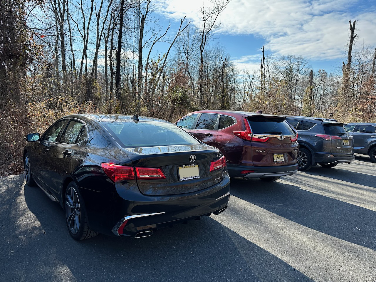 2020 Acura TLX parked in small parking lot with three other vehicles.