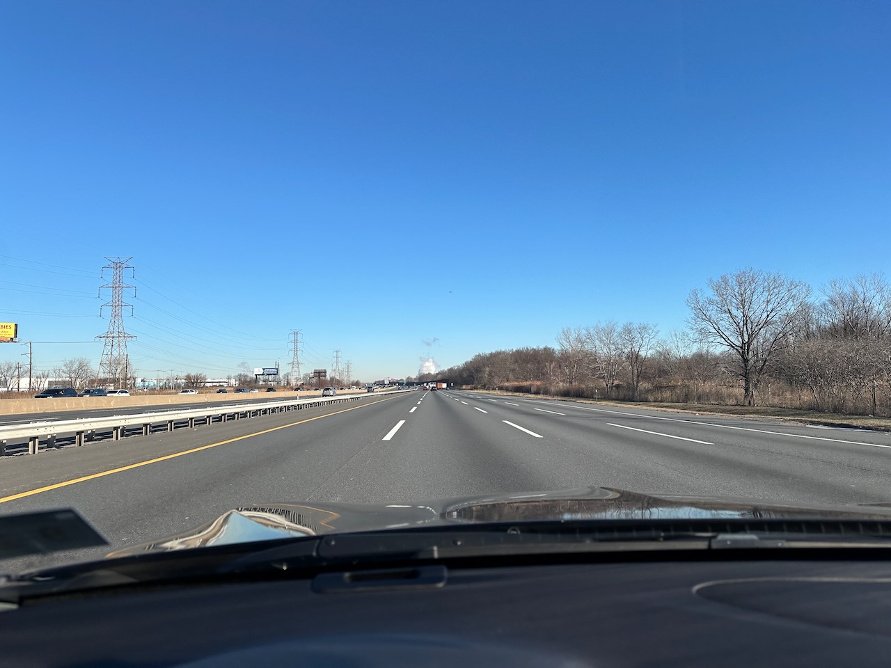 View of northbound New Jersey Turnpike, with no traffic in view, and sunny skies.