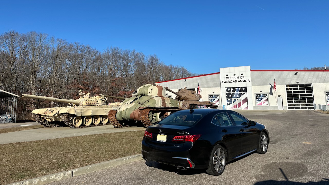 2020 Acura TLX parked in front of Museum of American Armor. Several tanks are in the background.