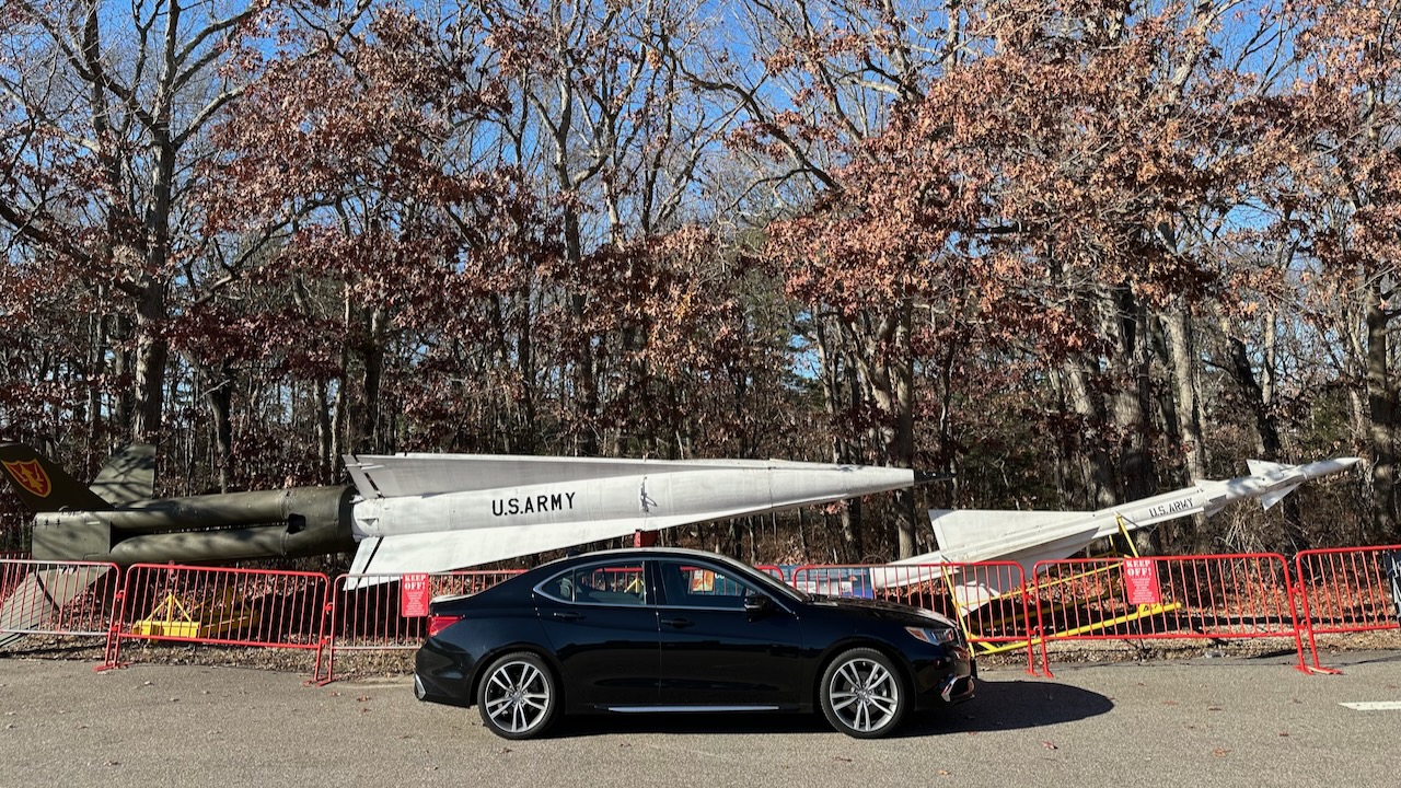 2020 Acura TLX parked in front of two missiles.