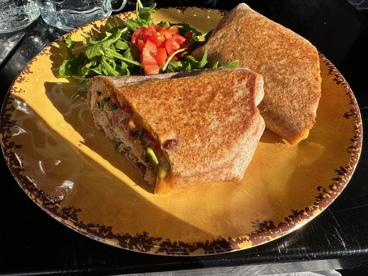 Wrap sandwich on plate with side of salad.