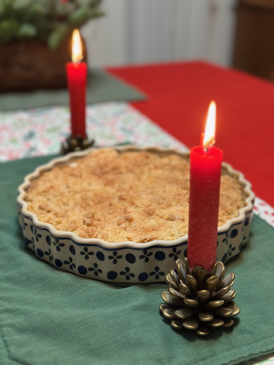 Apple crumble in pie plate, with two red candles lit on either side.