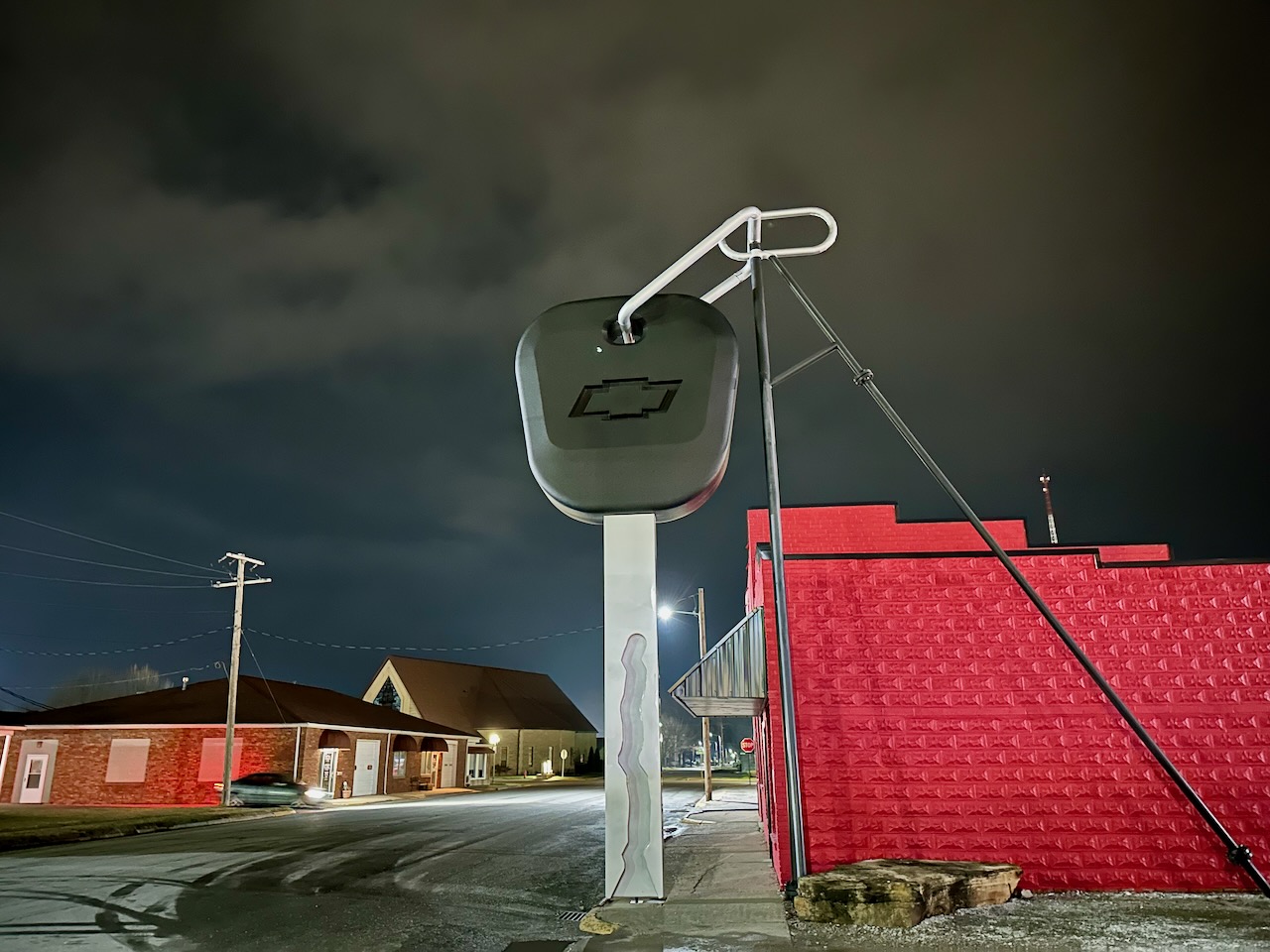 World's Largest Truck Key next to red-brick building along street.