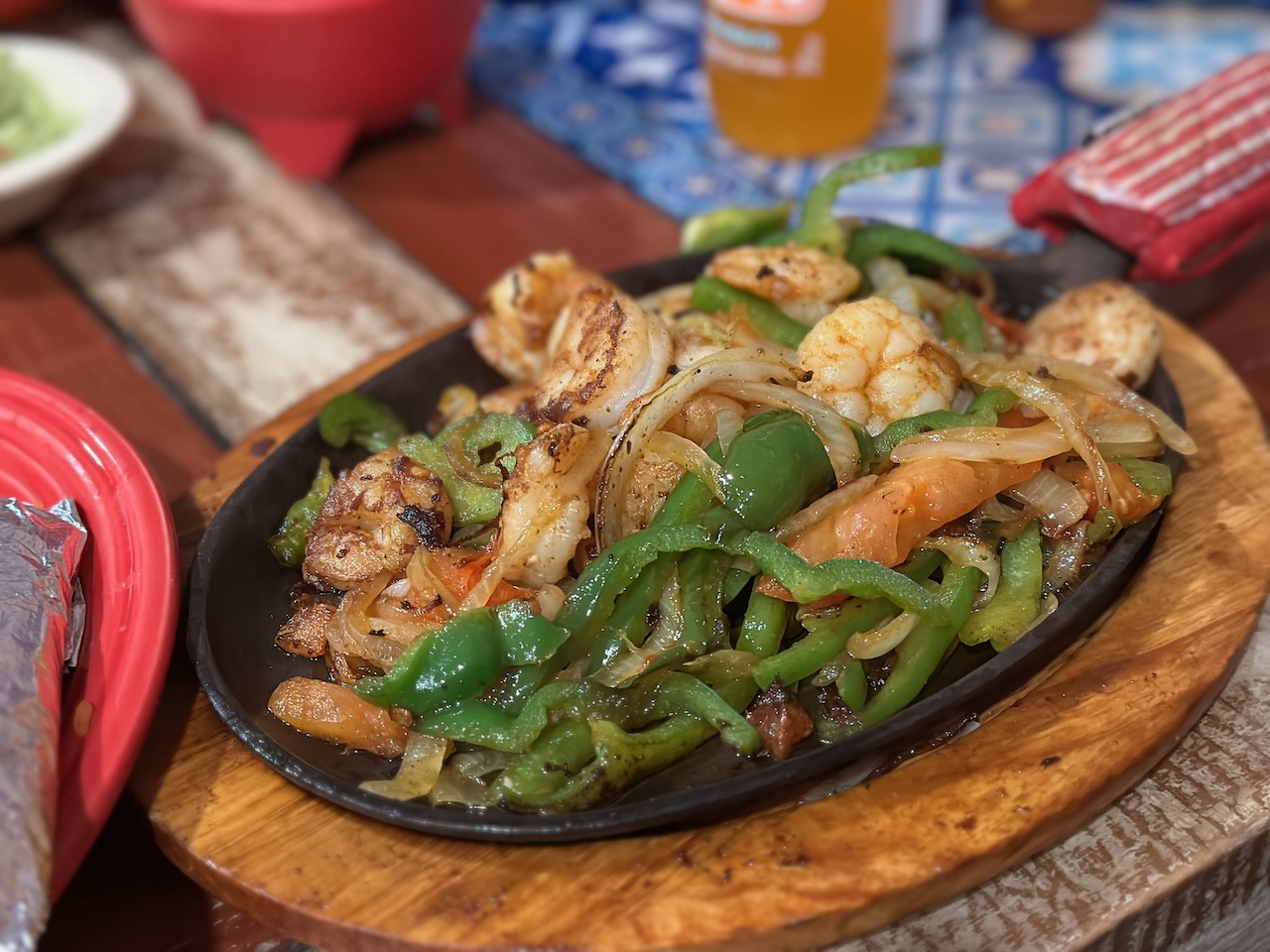 Shrimp fajita platter on sizzling skillet.