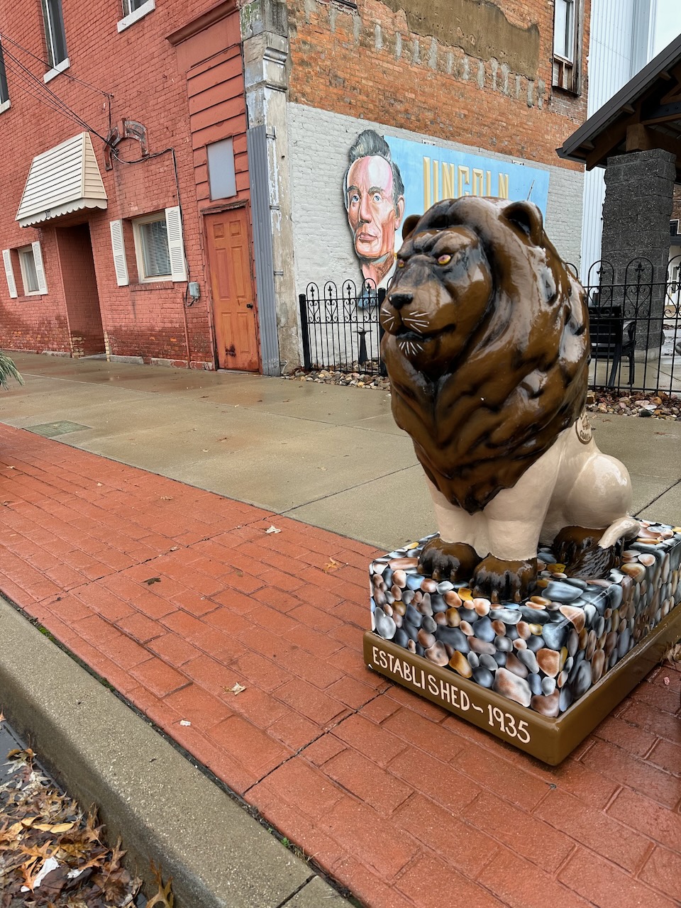 Statue of lion, painted brown and tan, with a base that says ESTABLISHED 1935.