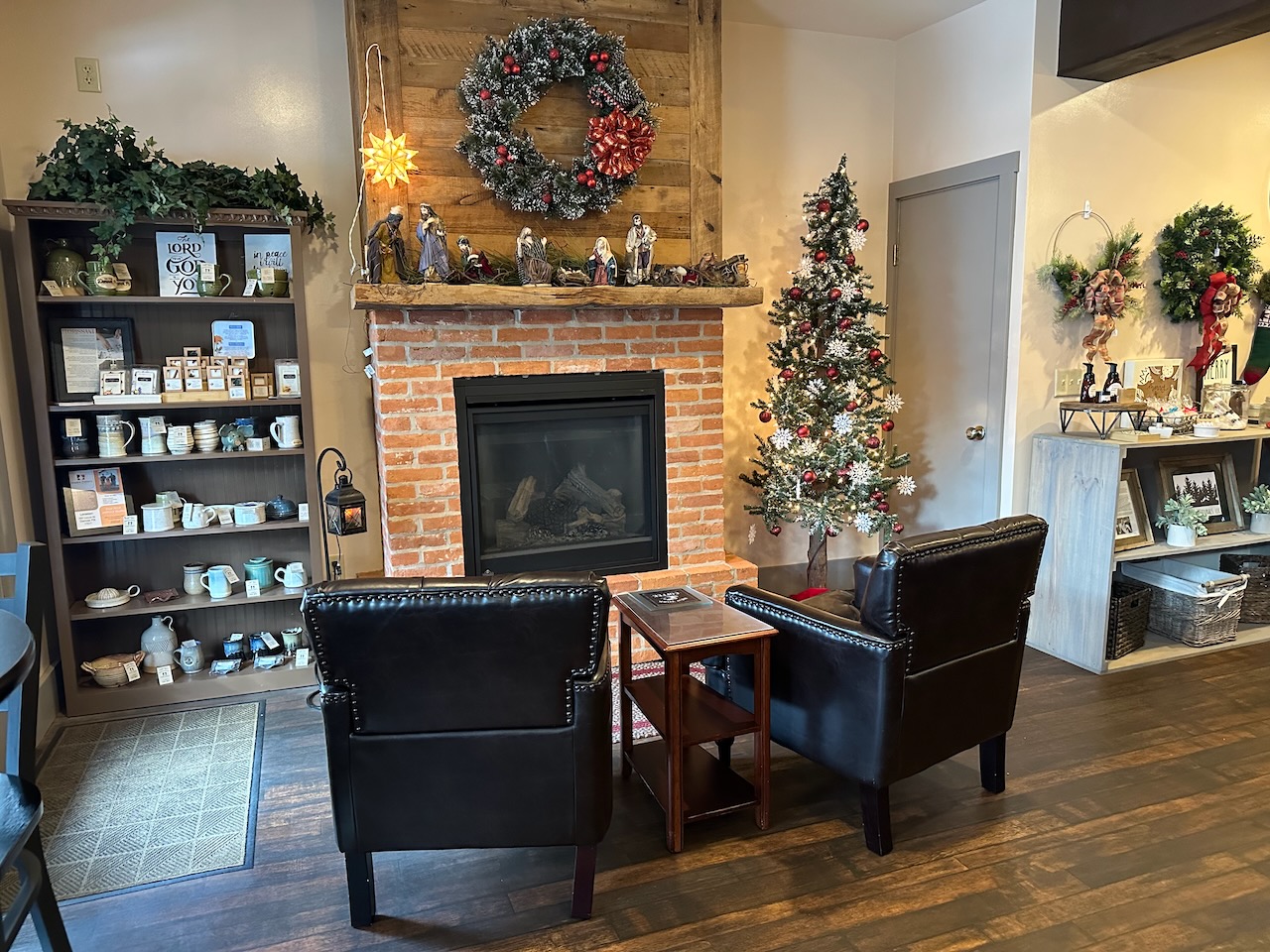 Interior of Courtyard Cafe, with a fireplace and two stuffed chairs in foreground.