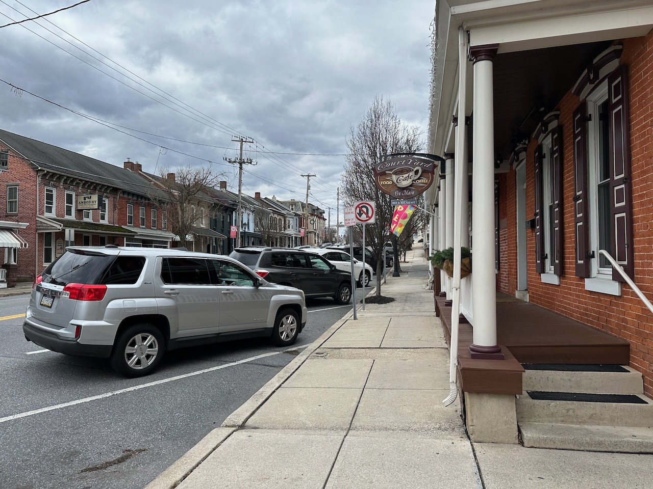 Exterior of Courtyard Cafe on Main Street in Denver, PA. Cars are parked in the street along the roadway.