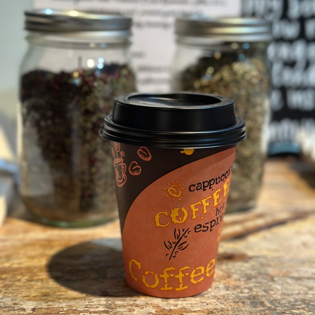 Paper coffee cup on wooden counter. 