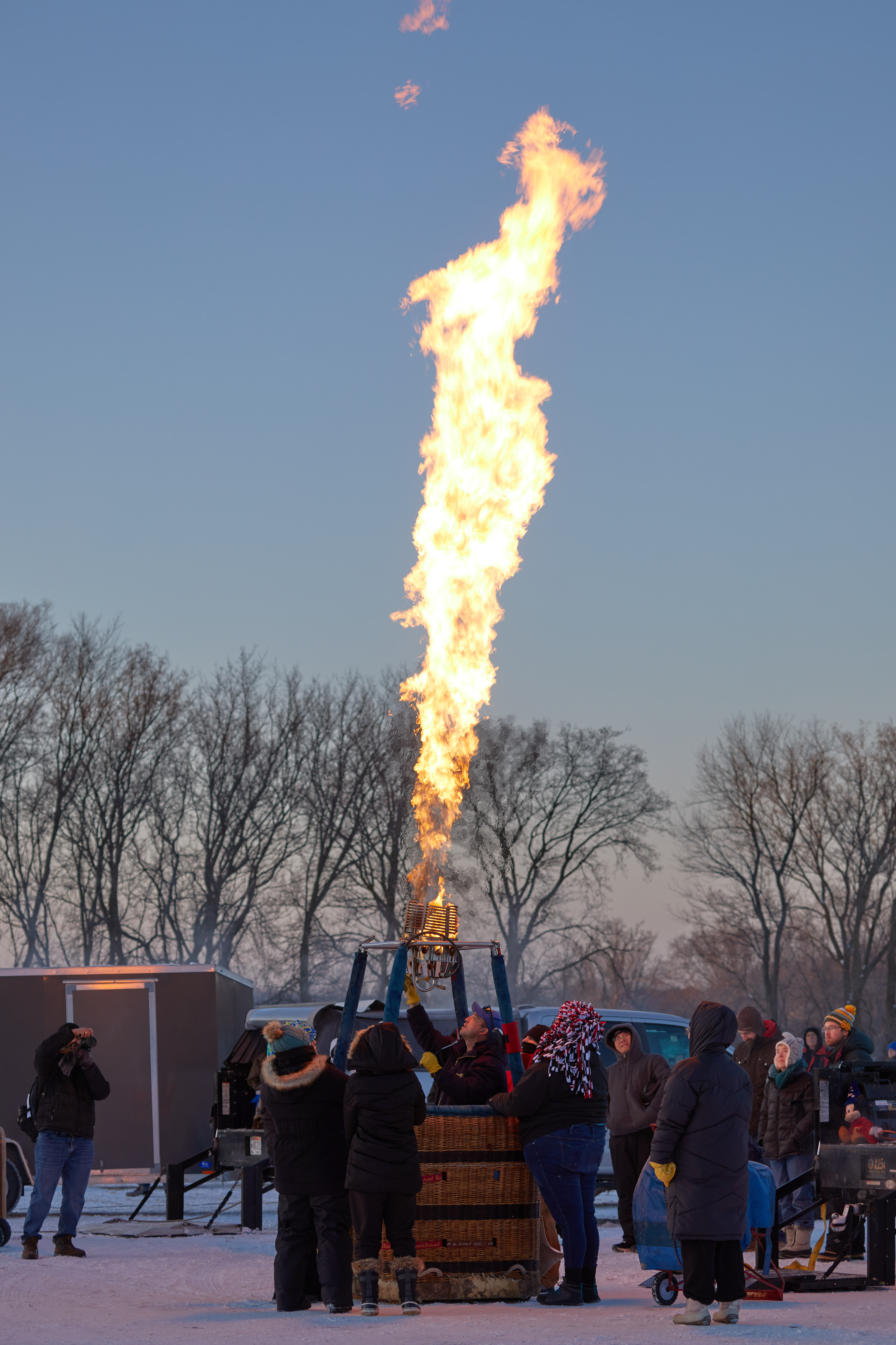 Column of flame from atop balloon basket. 
