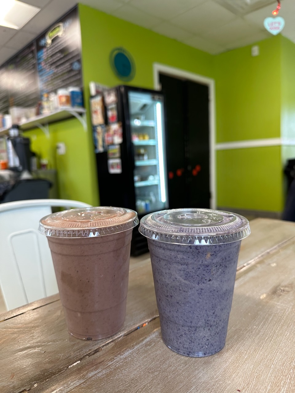 Two smoothies on counter of restaurant. 