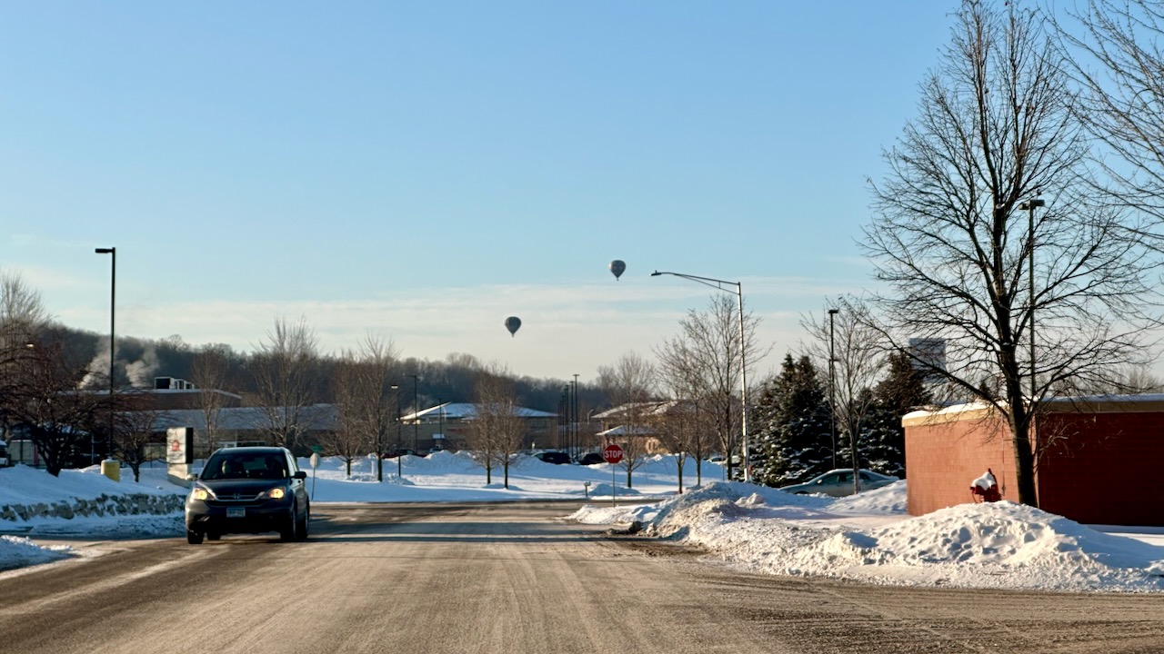Parking lot, with balloons in distance. 