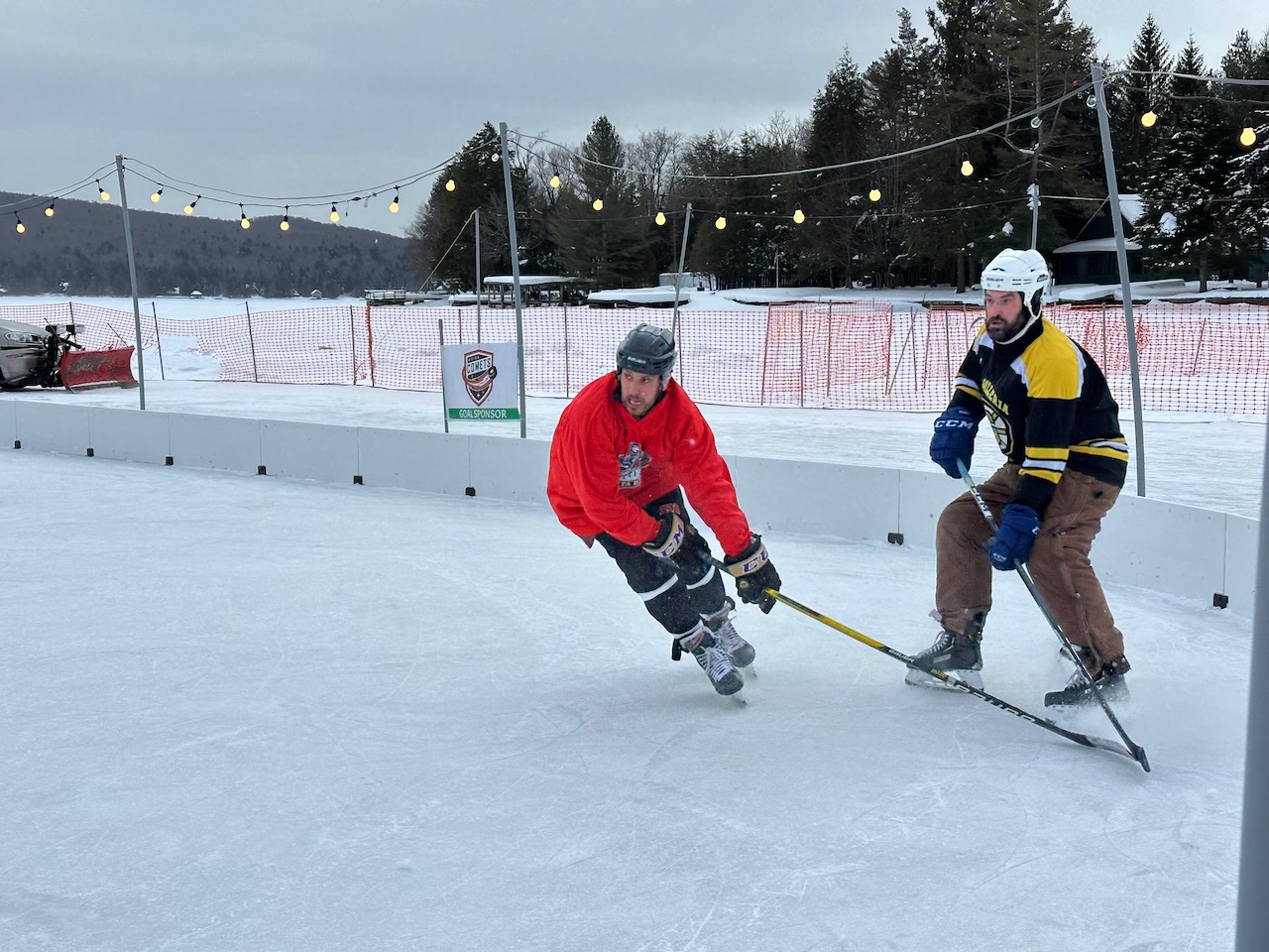 Two hockey players chasing puck on ice rink. 